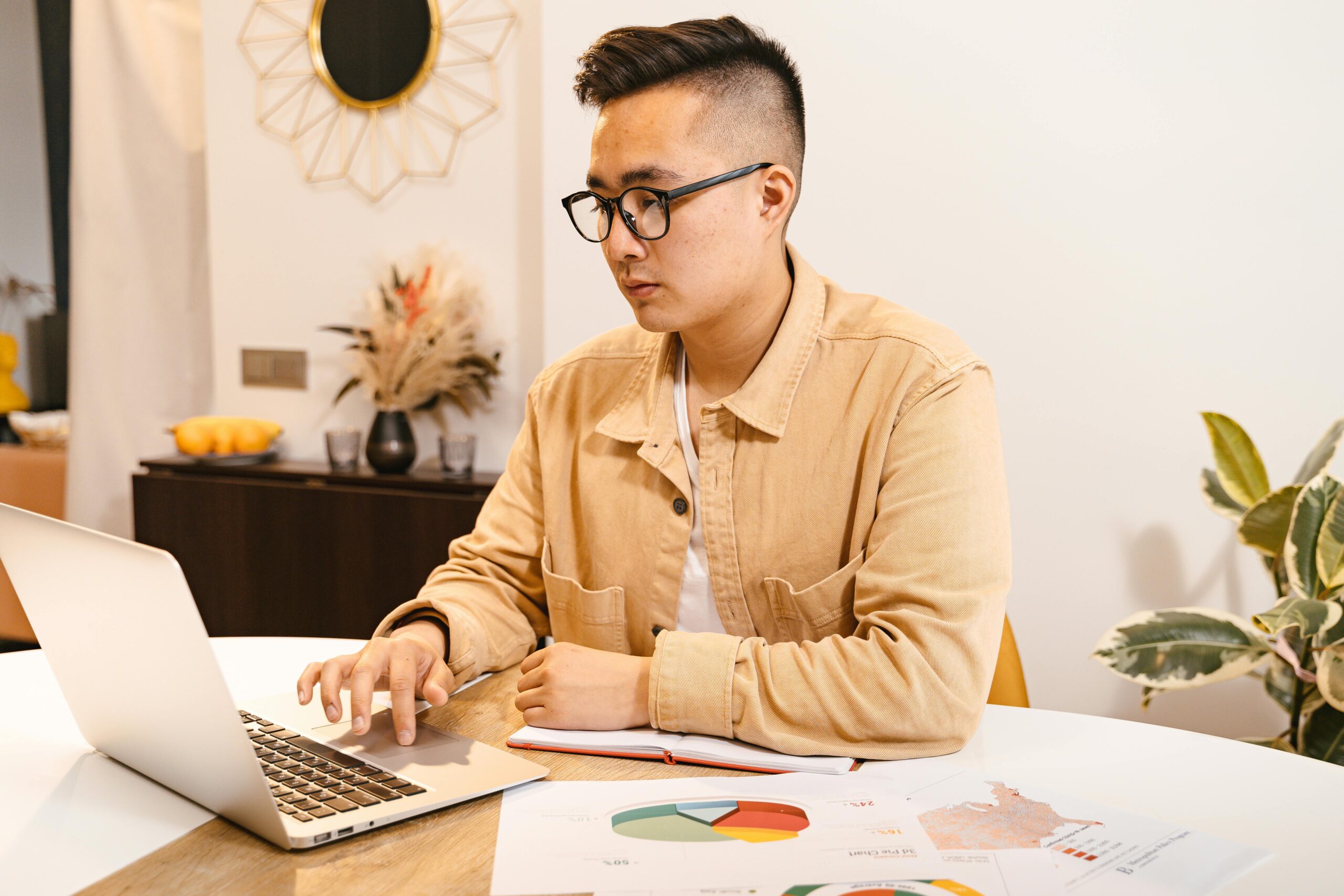 Young man doing accounting reconciliation from his laptop.